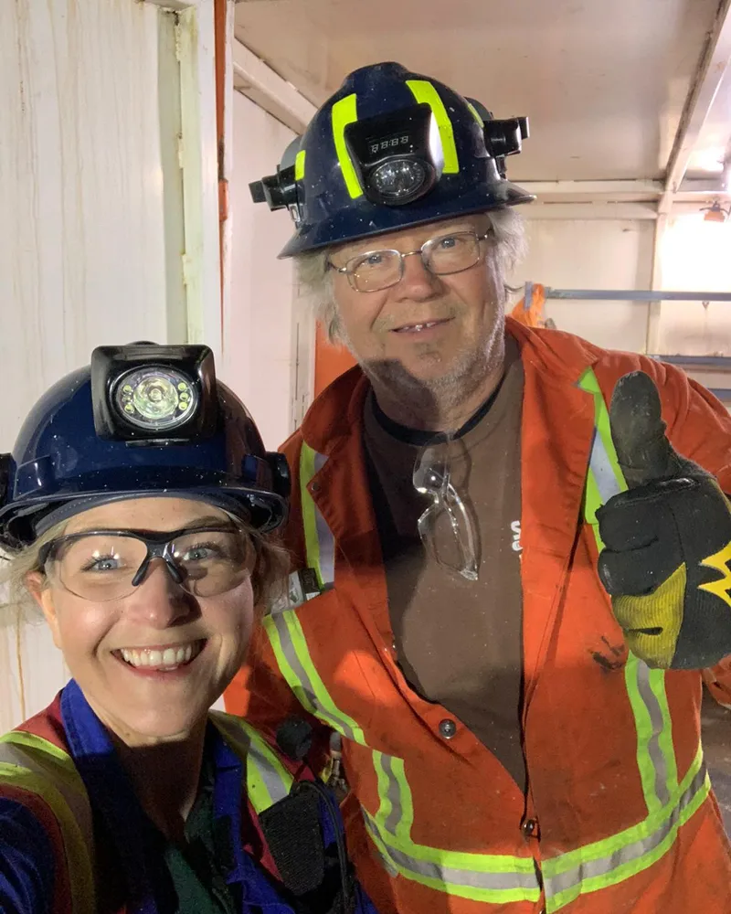 Two crew members in hard hats and headlamps